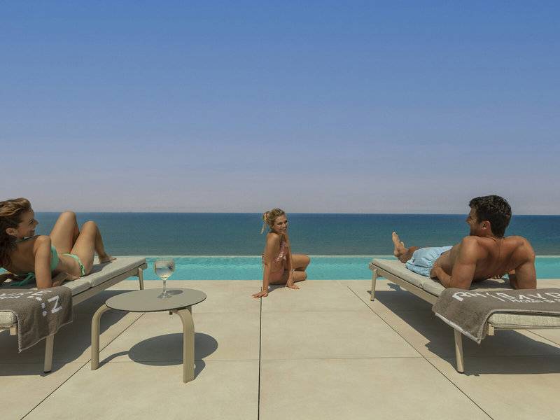 Vier Personen auf Loungeliegen mit Blick auf das Meer im RH Bayren & Spa