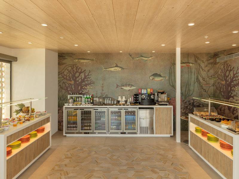 Frühstücksbereich des RH Bayren & Spa Hotels mit Fischmurals an der Wand.
