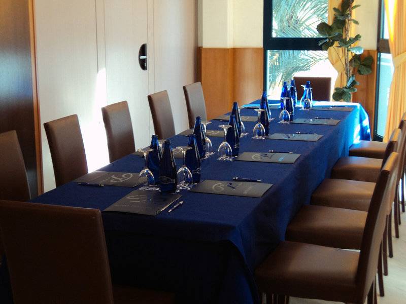 Konferenztisch im Hotel Principal Afilliated by RH mit blauer Tischdecke und blauen Flaschen.