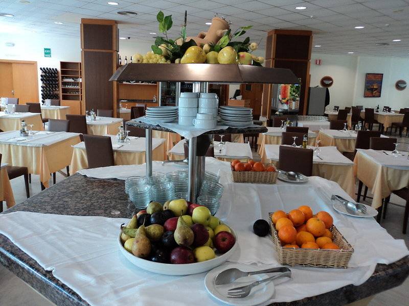 Ein Buffettisch in einem Restaurant mit einer Auswahl an Obst, Getränken und Geschirr.