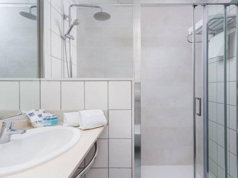 Badezimmer im Hotel Principal Afilliated by RH mit Dusche, Waschbecken und Handtüchern.