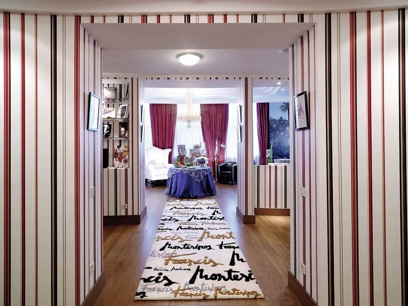 Der elegante Eingangsbereich des Westin Valencia Hotels mit einem langen Läufer und farbigen Wandverkleidungen.