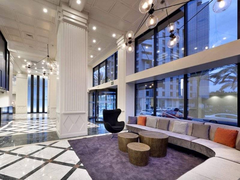 Hotellobby des Exe Rey Don Jaime mit modernem Design, einer Couch und einem schwarzen Stuhl.