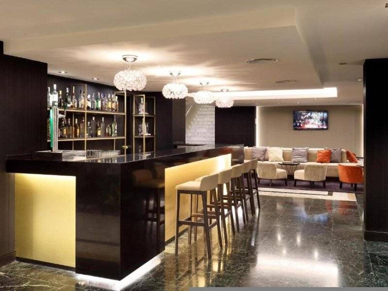 Bar im Hotel Exe Rey Don Jaime mit goldenen Akzenten und modernen Möbeln.