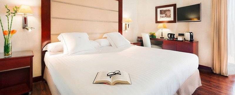 Hotelzimmer im Valencia Center Hotel mit offenem Buch und Brille auf dem Bett