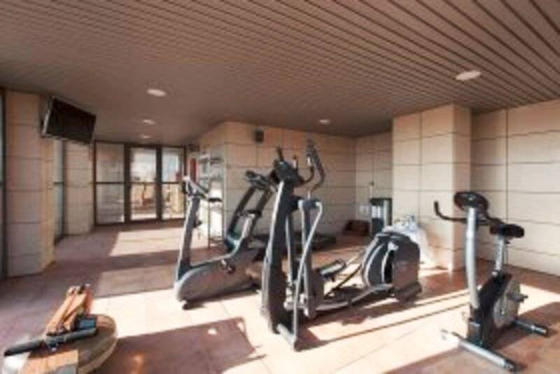 Fitnessbereich im Valencia Center Hotel mit Laufbändern, Fahrradtrainern und Hanteln.