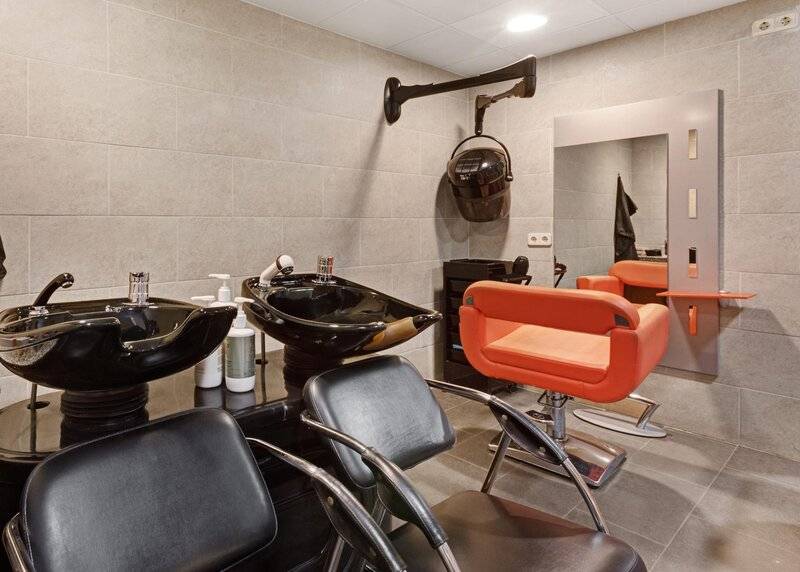 Friseursalon im ALUA Gran Camp de Mar mit modernen Stühlen und Waschbecken.