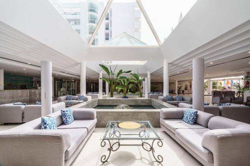Innenansicht des Hotellobbys mit Loungebereich und Wasserbrunnen im Zentrum.
