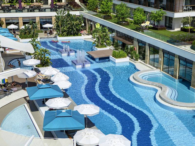 Luftaufnahme des TUI BLUE Side Pools mit Wasserfontaene und Sonnenschirmen
