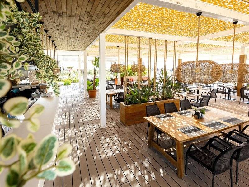 Terrasse des TUI BLUE Side Hotels mit Tischen, Stühlen und Pflanzen.