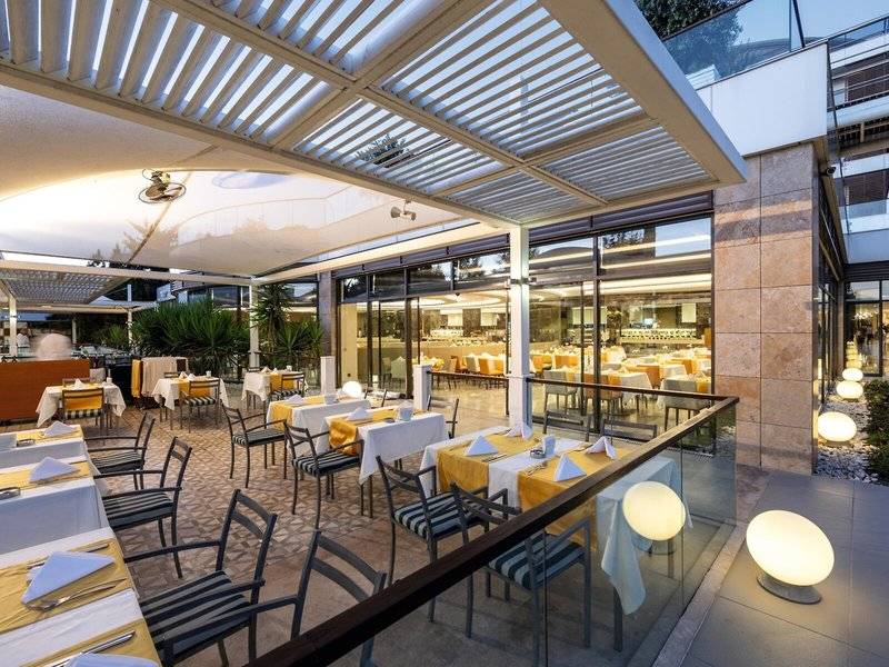 Restaurantterrasse des TUI BLUE Side Hotels mit gedeckten Tischen und Stühlen unter einem Sonnendach.