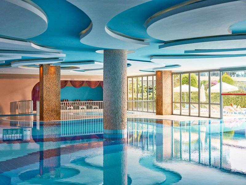 Innenpool des Magic Life Jacaranda Hotels mit blauen Decken und Säulen.
