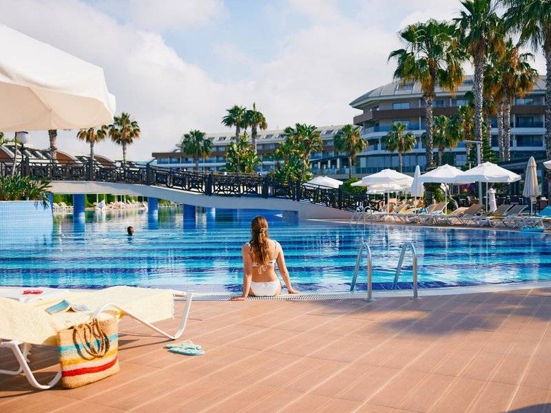 Ein Schwimmbadbereich des Magic Life Jacaranda Hotels mit einer Frau am Rand des Beckens.