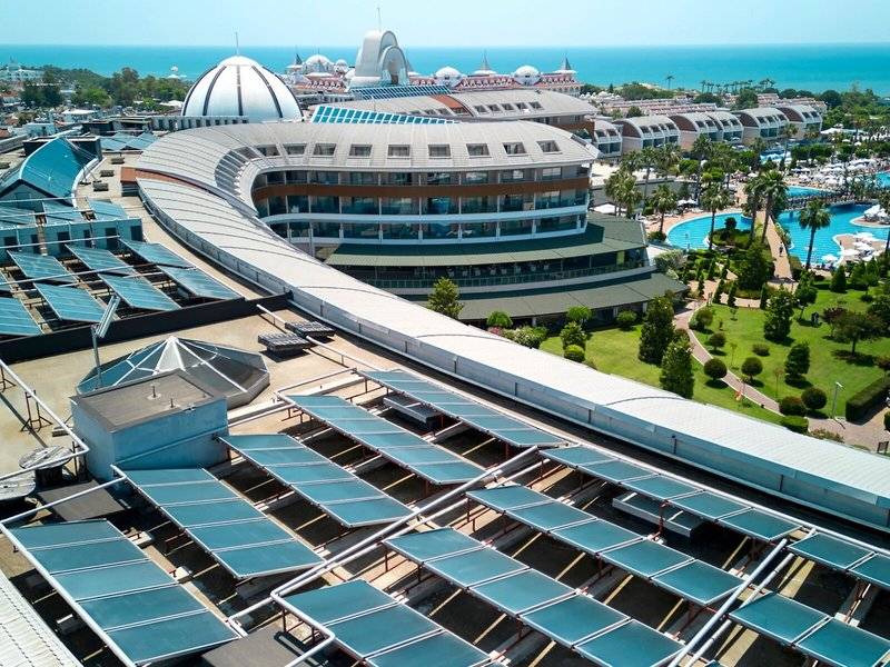Luftaufnahme des Magic Life Jacaranda Hotels mit Solarpaneelen, Gebäuden und Swimmingpools am Meer.