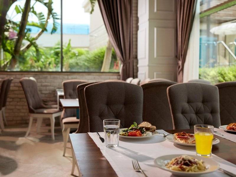 Frühstückstisch im Magic Life Jacaranda Hotel mit Speisen und Getränken.