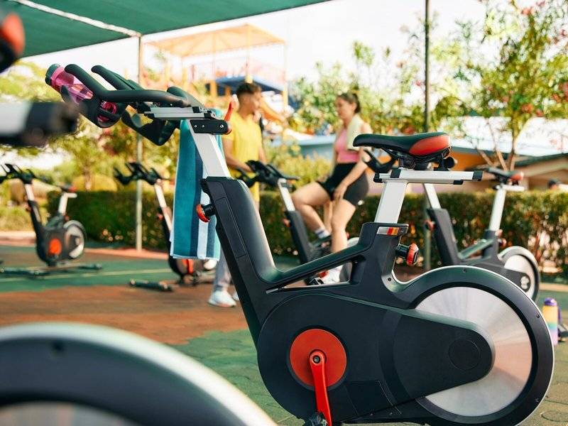 Fitnessräder unter einem Dach im Freien, mit zwei Personen, die sie benutzen