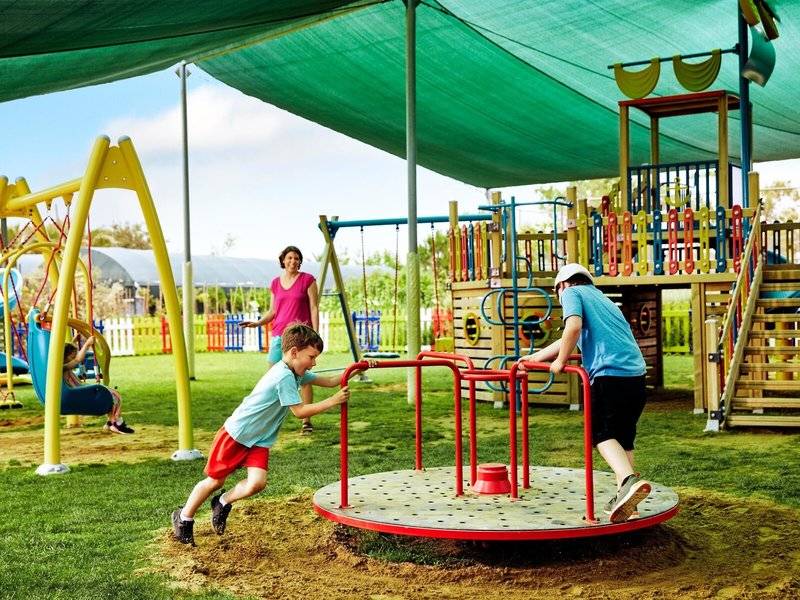 Kinder spielen auf einem Spielplatz im Magic Life Jacaranda Hotel.