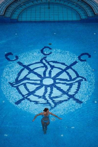 Frau schwimmt im Canyamel Classic Hotel im Innenpool mit Logo