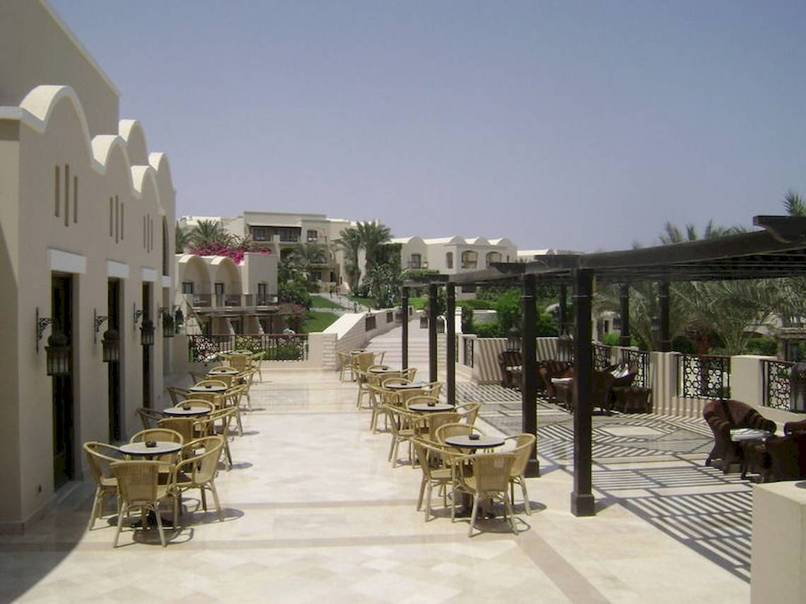 Außenbereich des Jaz Belvedere Resorts mit Tischen und Stühlen unter Pergolen.