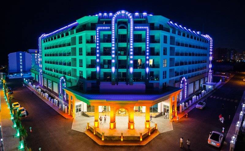 Nachtansicht des Lumos Deluxe Resort Hotel & Spa mit blauen und gelben Lichtern.