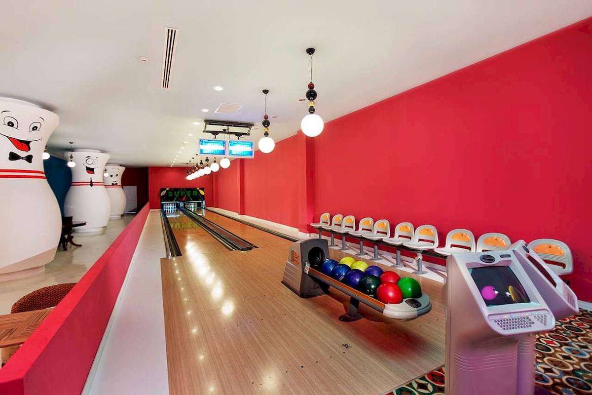 Bowlinghalle im Hotel Granada Luxury Okurcalar mit roten Wänden und Bowlingkugeln.