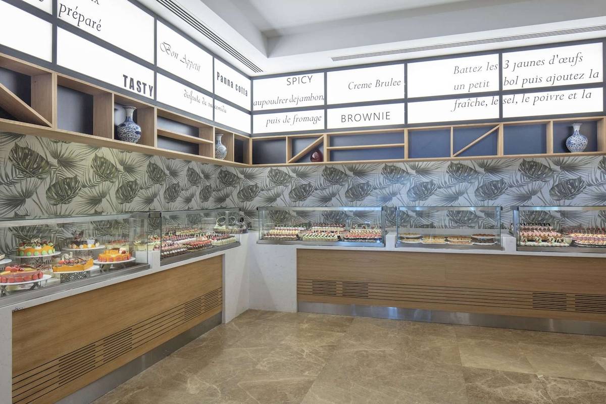 Die Patisserie im Hotel Granada Luxury Okurcalar mit verschiedenen Desserts und einer Wand mit verschiedenen Botschaften.