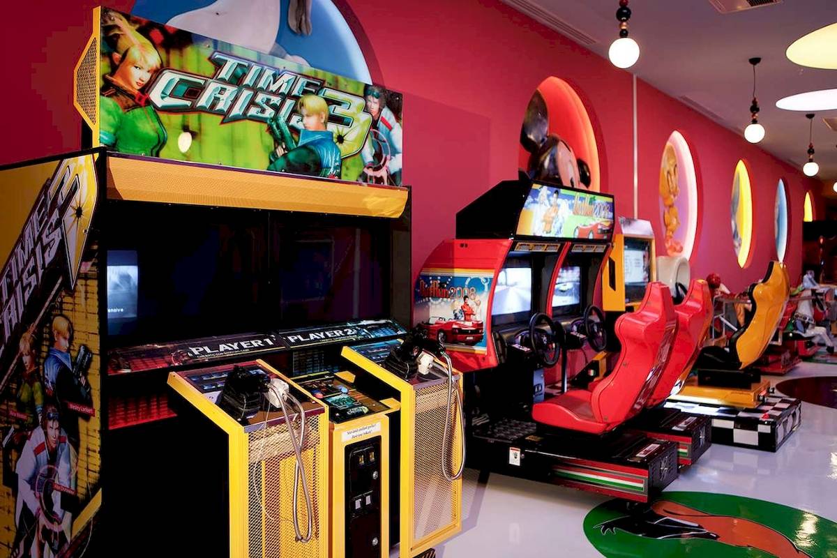 Spielhalle im Hotel Granada Luxury Okurcalar mit Arcade-Spielen und roten Sitzen.