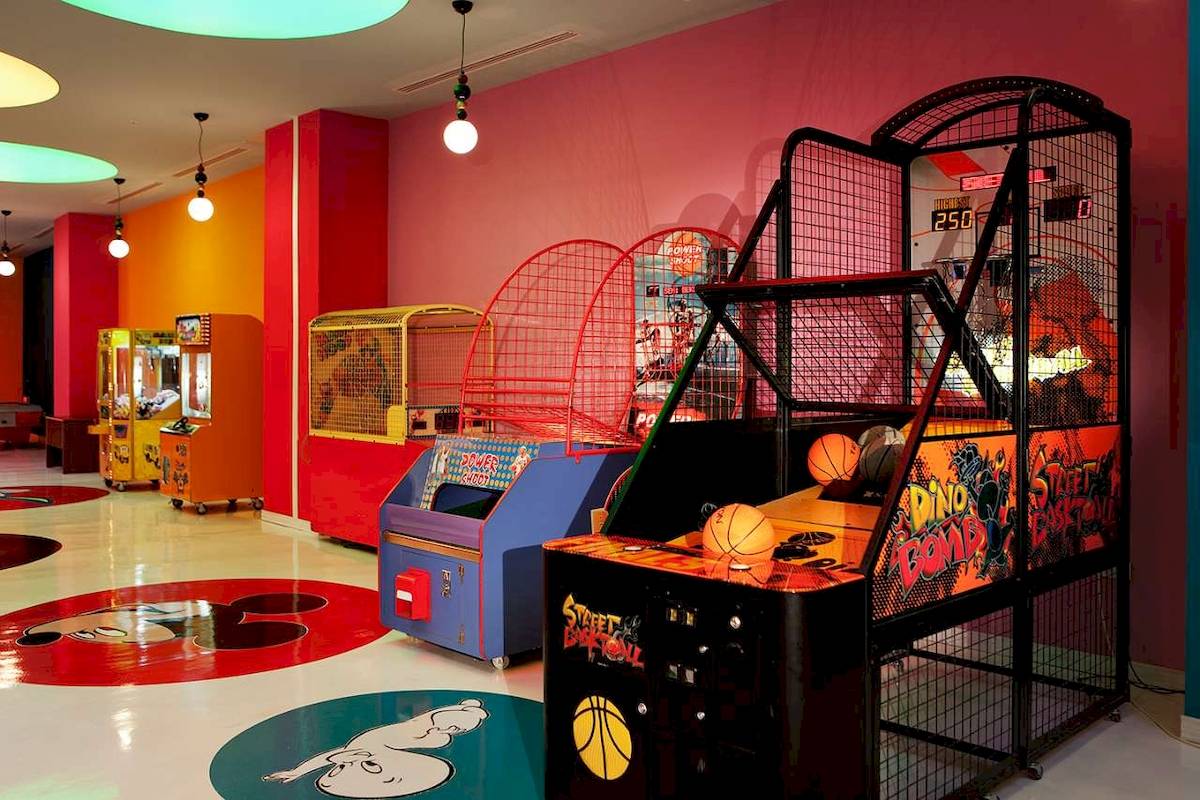 Spielraum mit verschiedenen Arcade-Spielautomaten und bunten Bodenaufklebern im Hotel Granada Luxury Okurcalar.