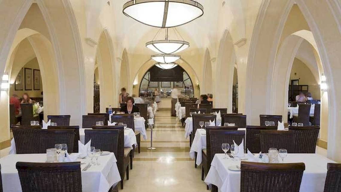 Innenansicht des Jaz Belvedere Resort Restaurants mit gedeckten Tischen und eleganten Kronleuchtern.