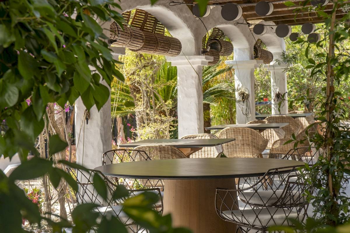 Terrasse des Paraiso de los Pinos Hotels mit Tischen und Stühlen unter Überdachungen