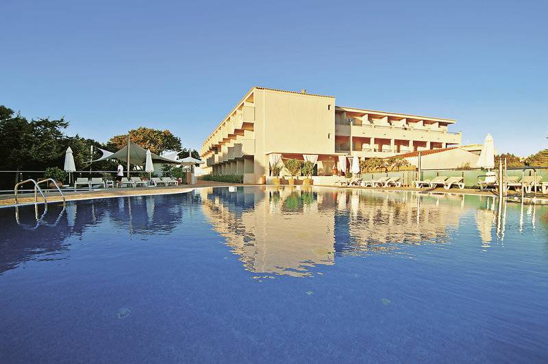 Außenpool des Tahiti Hotels mit Hotelgebäude im Hintergrund und Sonnenliegen.