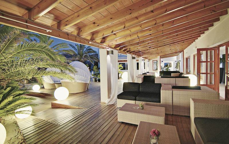 Loungebereich im Tahiti Hotel mit Holzboden, weißen Kissen und Laternen.