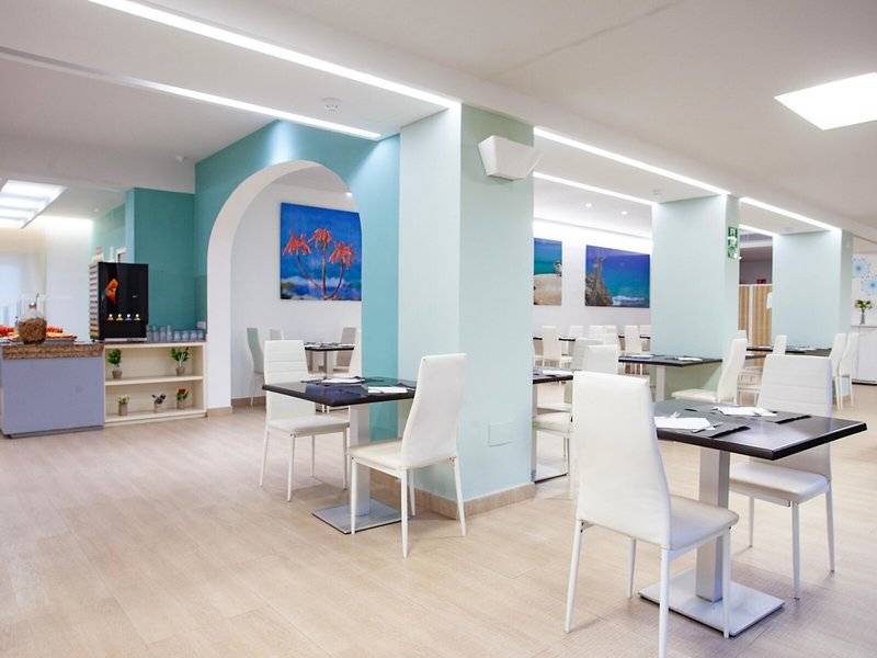 Innenansicht des Restaurants im Hotel Rosales Formentera mit blauen Wänden und weißen Möbeln.