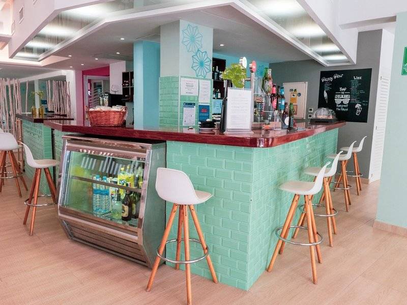 Rezept Theke im Rosales Formentera Hotel mit grünen Wänden und weißen Stühlen.