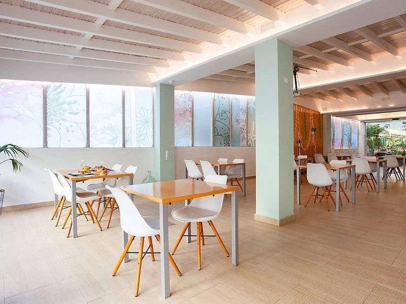 Frühstücksbereich im Rosales Formentera Hotel mit modernen Tischen und Stühlen.