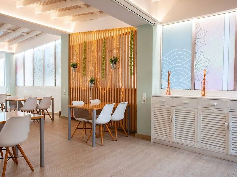 Inneneinrichtung des Rosales Formentera Hotels mit hölzerner Wand, Pflanzen und modernen Möbeln.