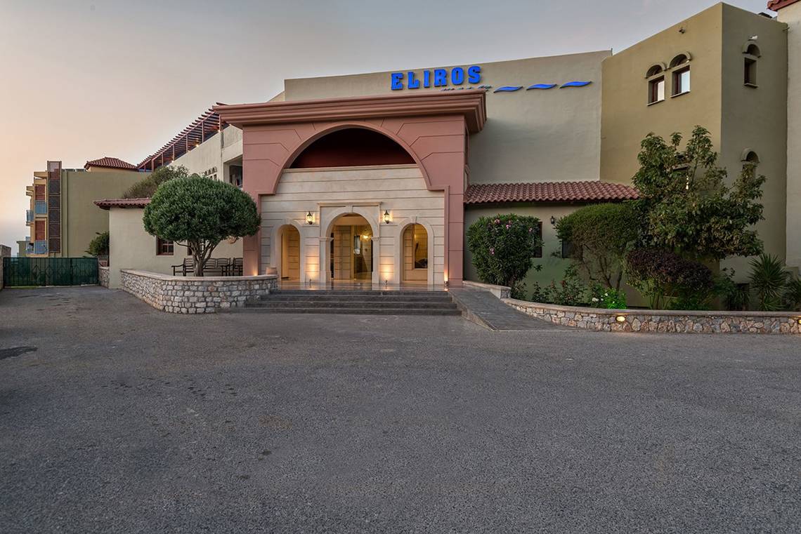 Vorderansicht des Eliros Mare Hotels mit Haupteingang und beleuchteten Stufen.