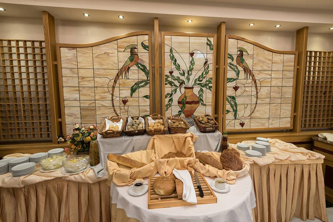 Buffet-Tisch mit Brot im Eliros Mare Hotel, geschmückt mit bunten Glasmalereien.