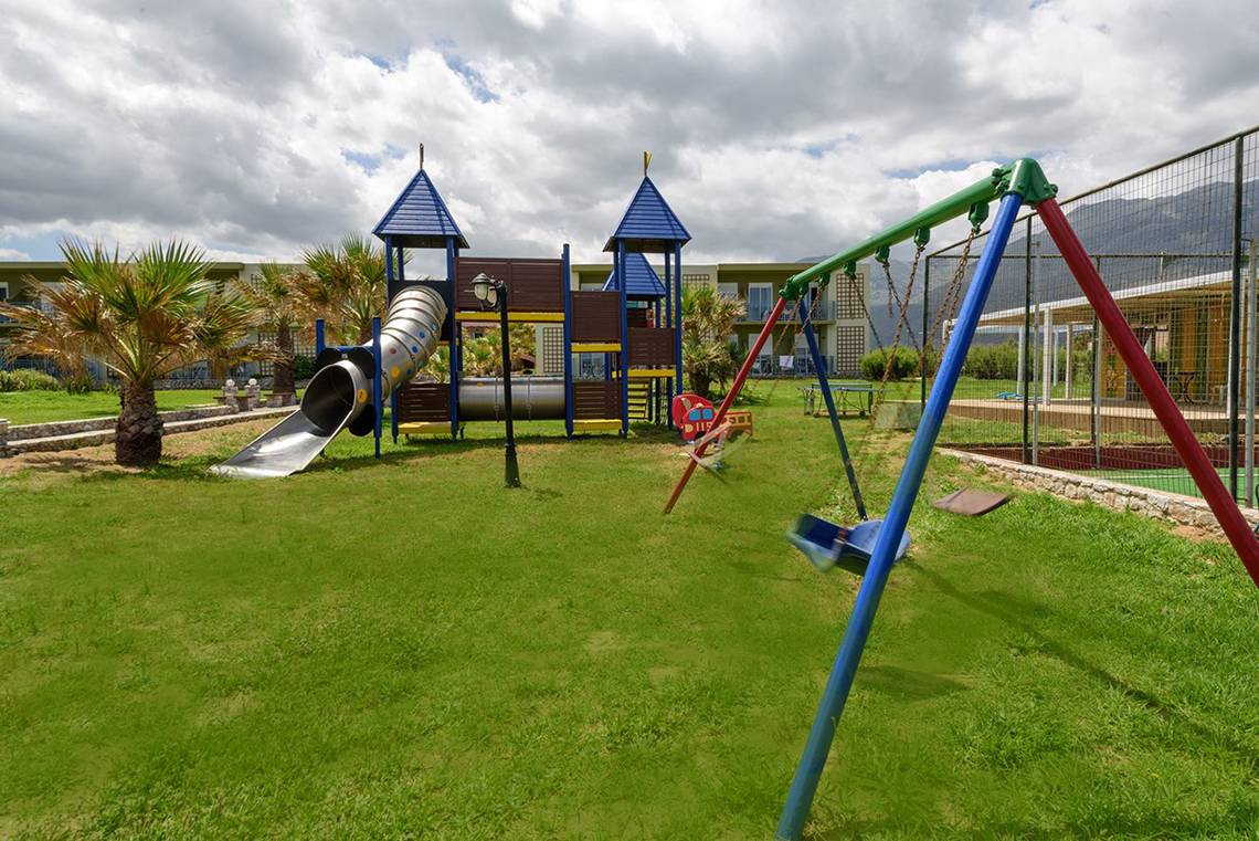 Spielplatz im Freien mit Rutsche und Schaukeln im Eliros Mare Hotel.