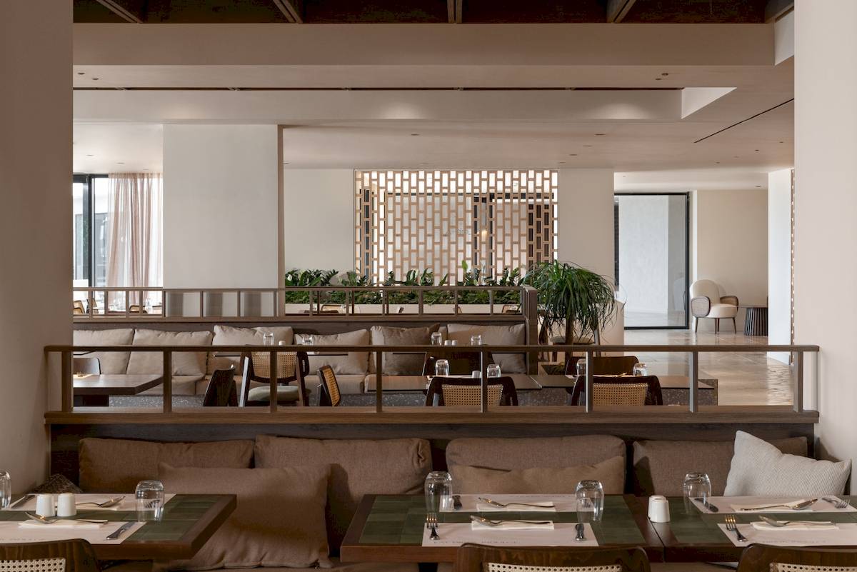 Innenraum des Restaurants im Helea Lifestyle Beach Resort mit Tischen, Stühlen und Pflanzen.