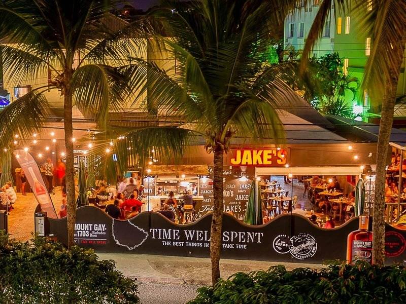 Außenbereich des Coconut Court Beach Hotels bei Nacht mit beleuchteten Palmen und Gästen.
