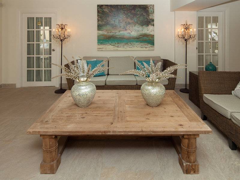 Wohnzimmer des Sugar Bay Barbados Hotels mit einem großen Couchsofa, zwei Vasen und einer Leinwand.
