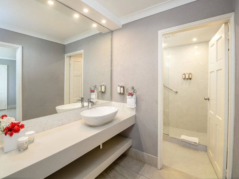Badezimmer im Sugar Bay Barbados Hotel mit großem Spiegel und Glasdusche.