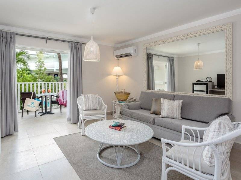 Wohnzimmer von Sugar Bay Barbados mit Sofa, Tisch, Stühlen und Spiegel