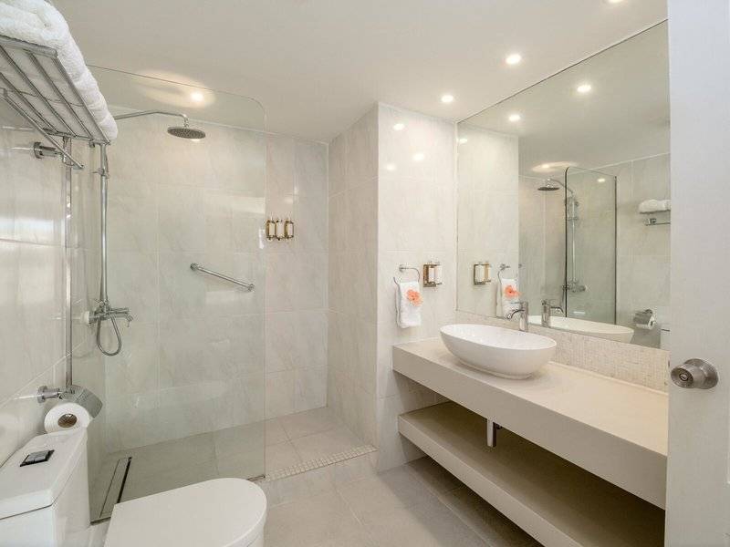 Badezimmer im Sugar Bay Barbados Hotel mit Glasdusche, Waschbecken und Toilette.