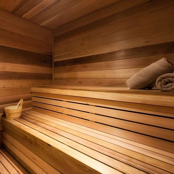 Sauna im Hilton Barbados mit Holzwänden und -bänken sowie einem Holzeimer