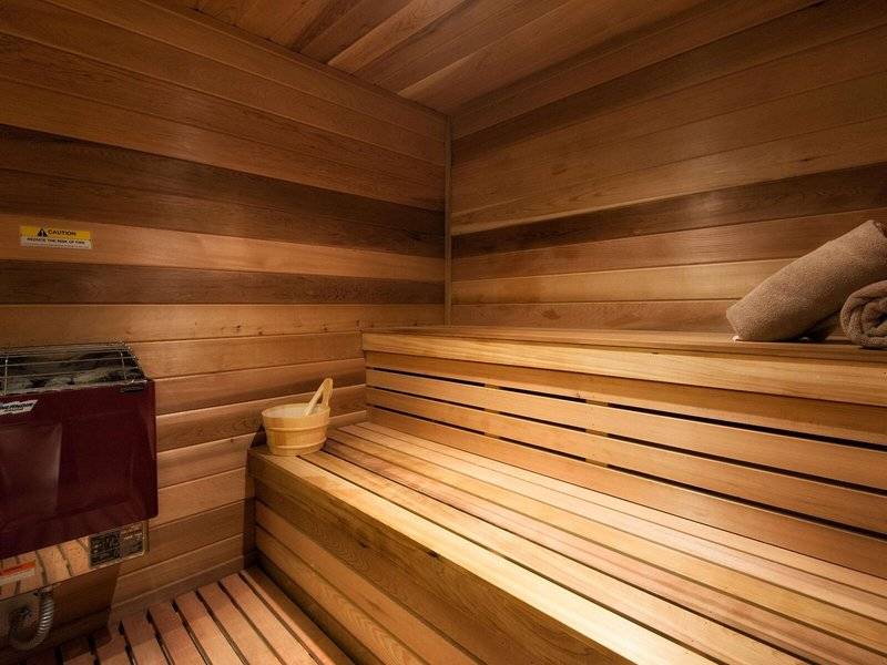 Innenraum einer Sauna im Hilton Barbados Hotel mit Holzwänden und Bänken.