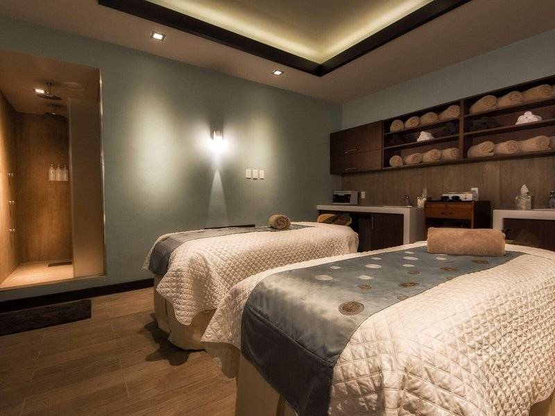 Spa-Massageraum im Hilton Barbados mit zwei Betten und Einrichtungen.