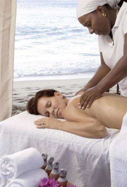 Frau im Hotel Mango Bay Hotel am Strand eine Massage erhaltend