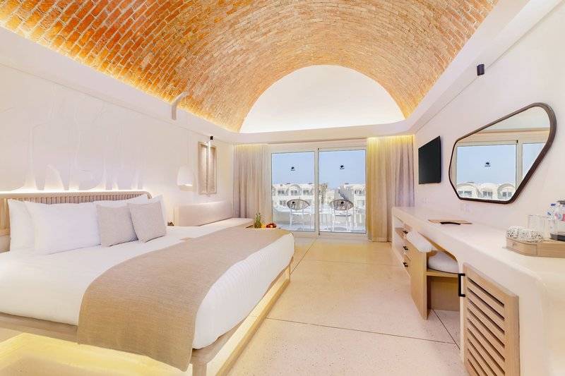 Innenansicht eines Schlafzimmers im Sunrise Anjum Resort mit einem Bett und einer Aussichtsterrasse.